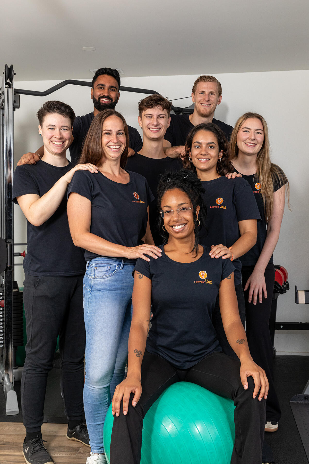 Das Team der OsteoVital GmbH in der Praxis in Sissach, vor dem Trainingsgerät